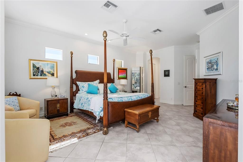 Primary Bedroom with Bay Widow Overlooking Water and Pool and French Doors to Lanai