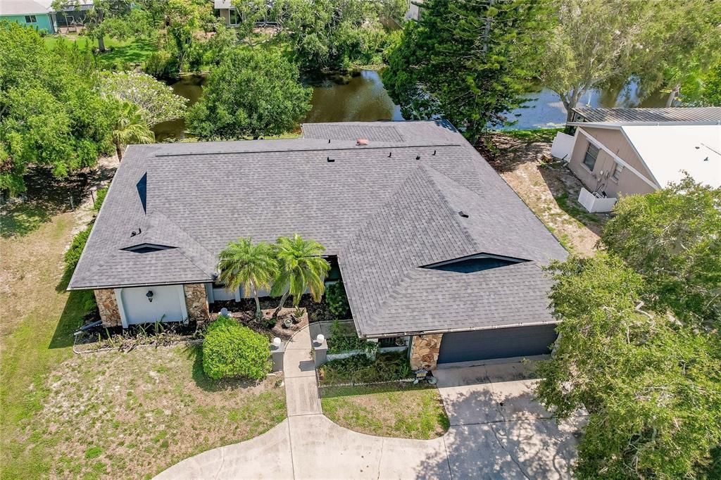 AERIAL VIEW OF ROOF INSTALLED 2023 W/CANAL BEHIND HOM