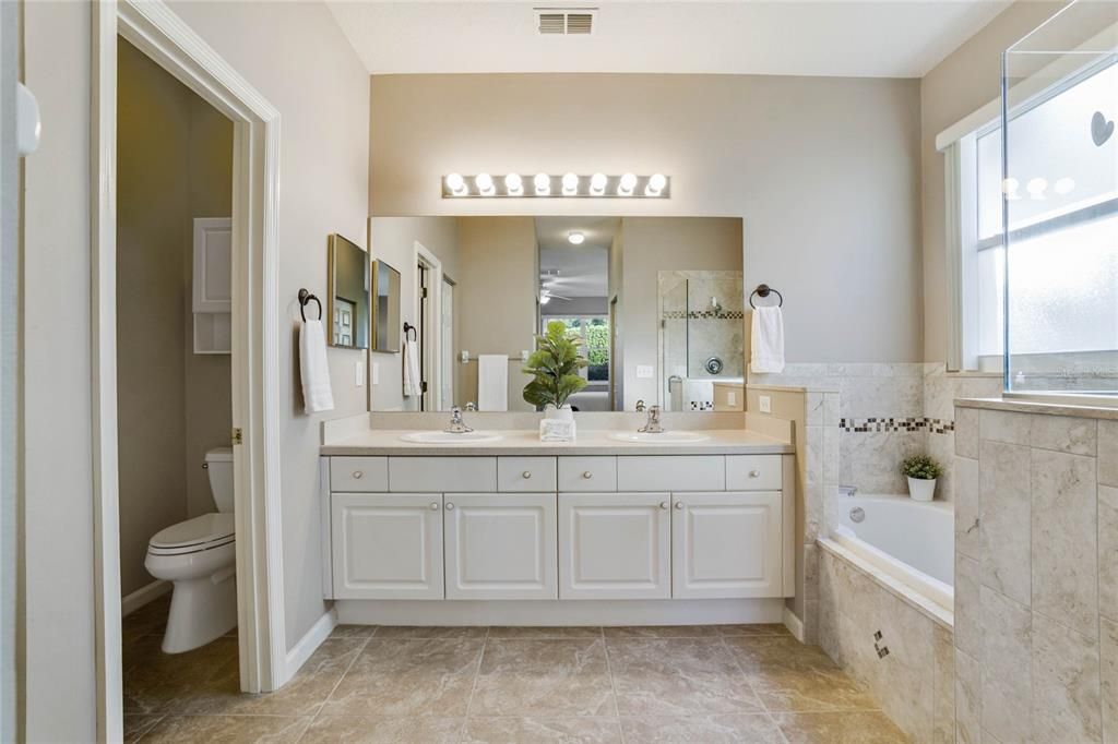 Primary Bathroom w/ dual sinks, soaking tub & frameless glass enclosed walk-in shower