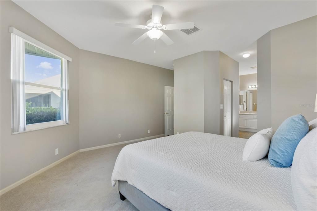 Primary Bedroom w/ several windows for natural light overlooking the private backyard