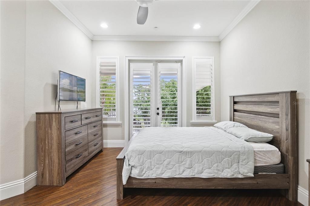 Bedroom #5 with access to the exterior balcony overlooking the pool and lake