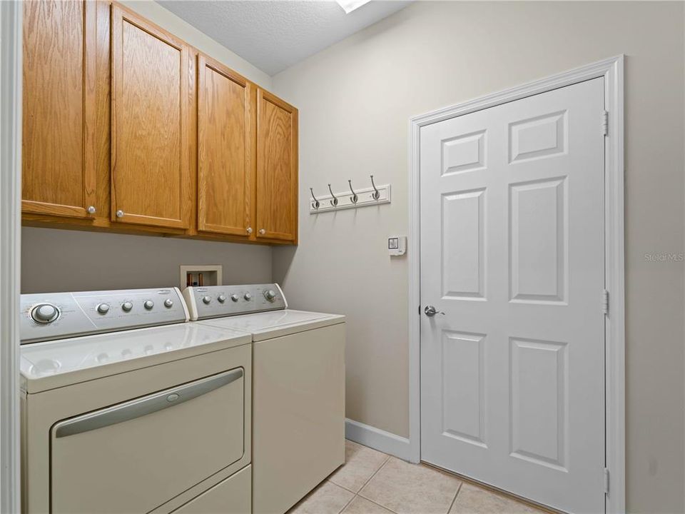 Laundry Room with ample Storage Cabinets conveniently located with entrance to Garage.