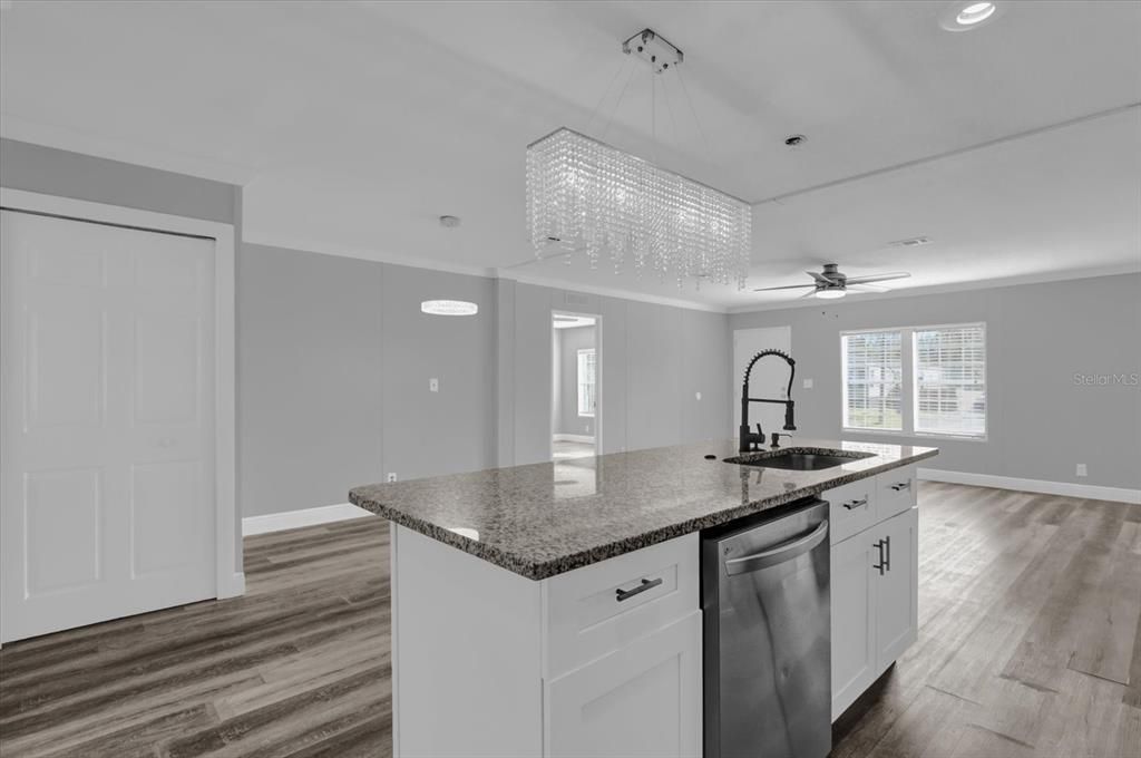 The kitchen island serves as a stylish centerpiece, offering ample counter space perfect for meal prep, casual dining, or gathering with loved ones.