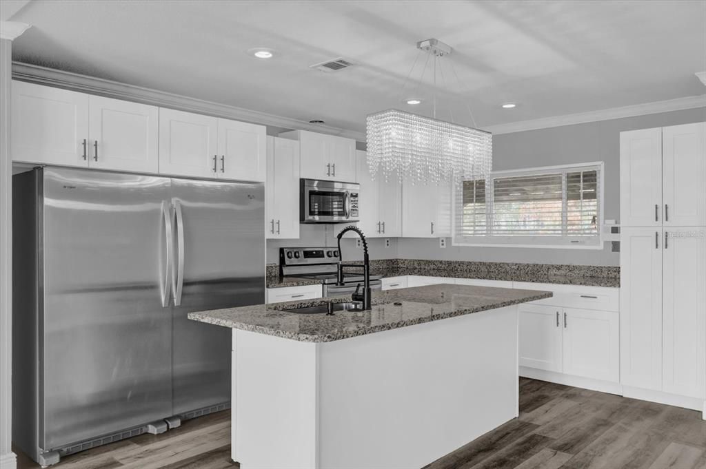 Gorgeous kitchen that includes a sophisticated chandelier and brand new cabinets