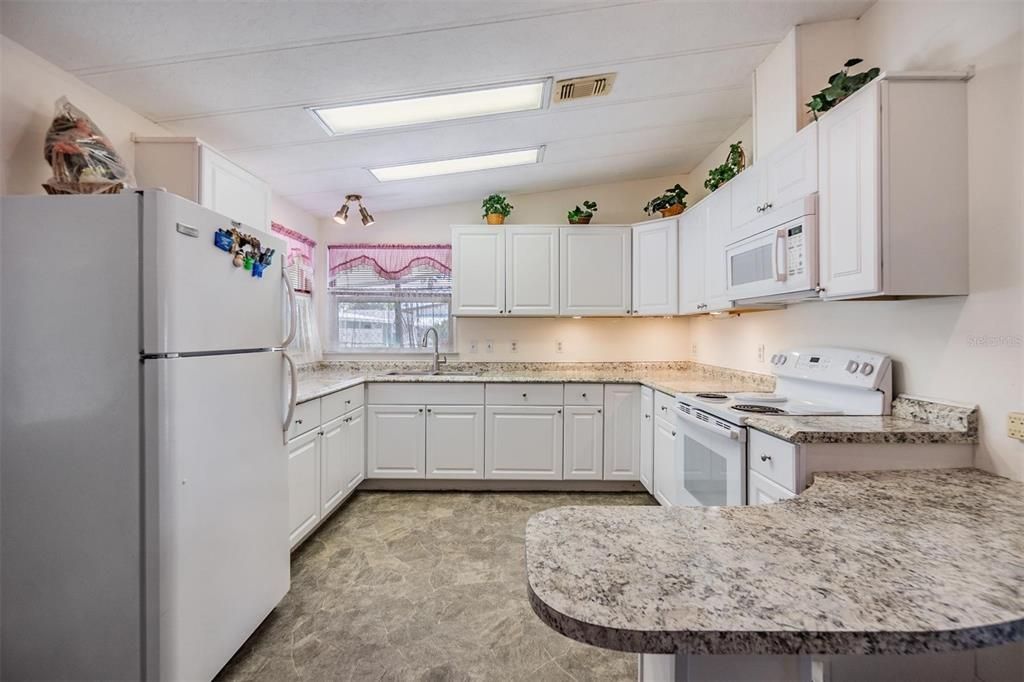 Nice open kitchen with updates including counter tops, cabinets, and fixtures.