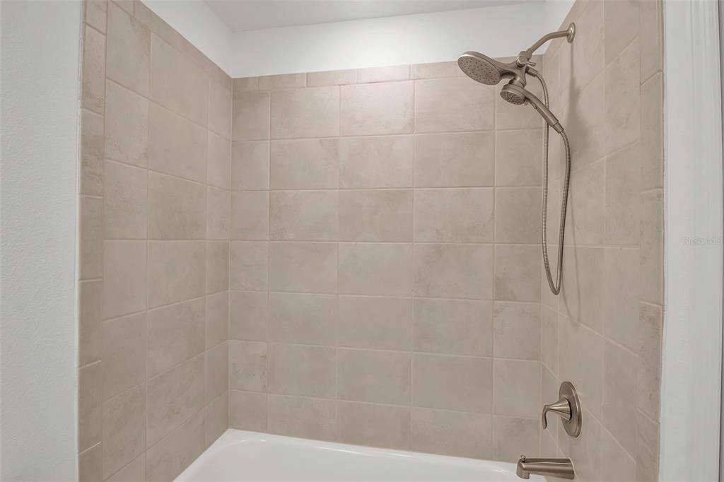 Guest bath features shower/ tub and brushed gold fixtures