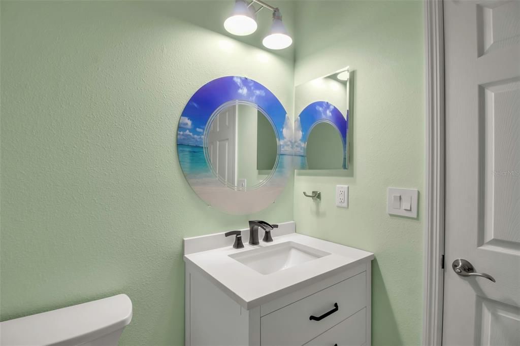 Half bath with custom mirror and quartz top vanity