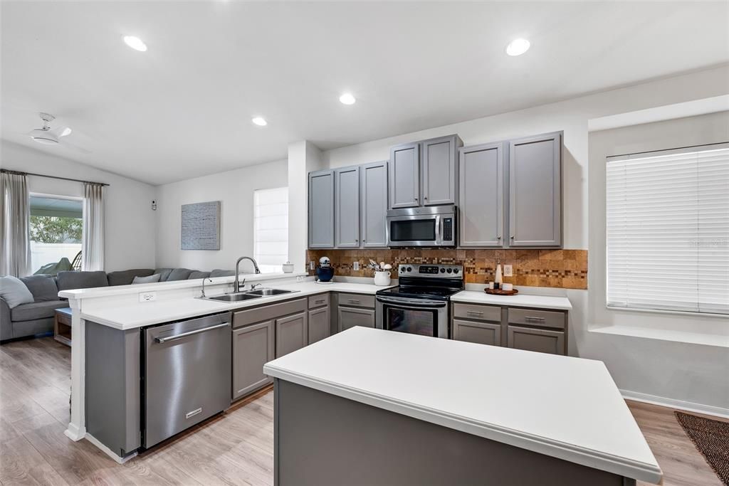 The kitchen layout seamlessly flows into the family room through a convenient breakfast bar, creating a perfect transition between the two spaces.