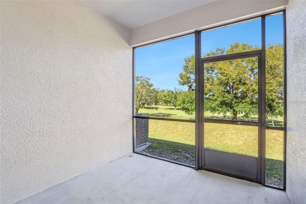 SCREENED LANAI HAS GOLF COURSE VIEWS.