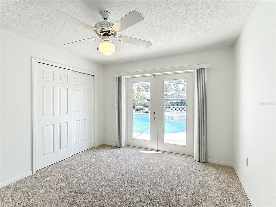 Bedroom 3 with French doors leading to the pool