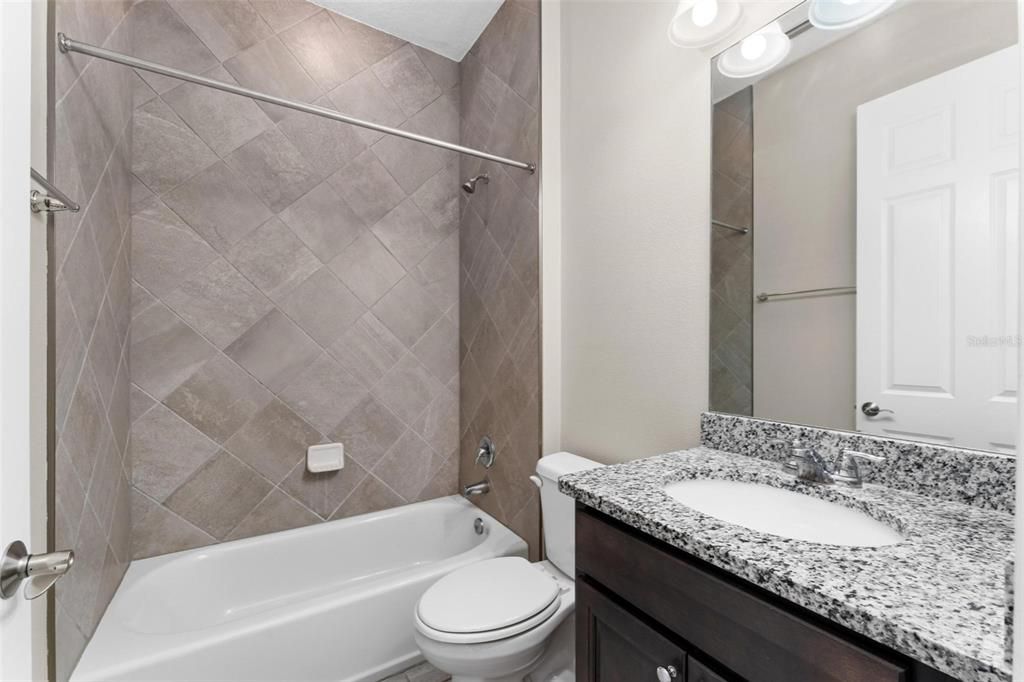 Beautiful custom tiled shower in bedroom 3's private bath.