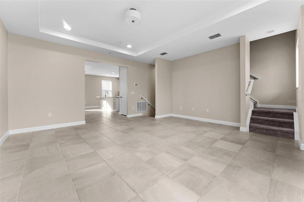 Beautiful great room with a coffer ceiling, gorgeous tiled floors, recessed lights, a wall large enough for any size TV.