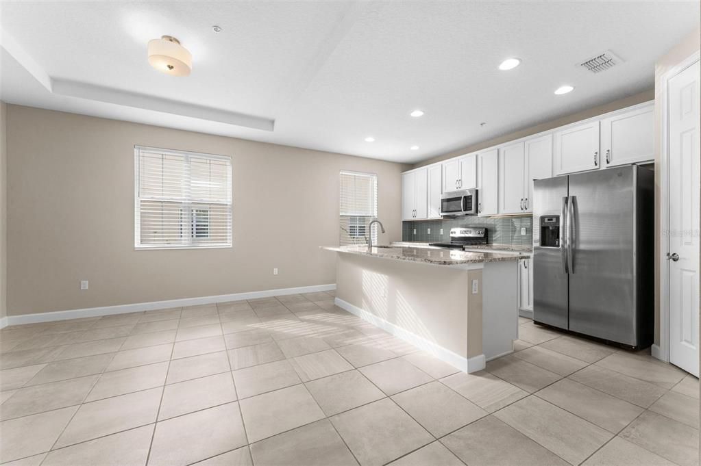 Spectacular dining area off the opened kitchen features a coffer ceiling and window to let the sun stream in.