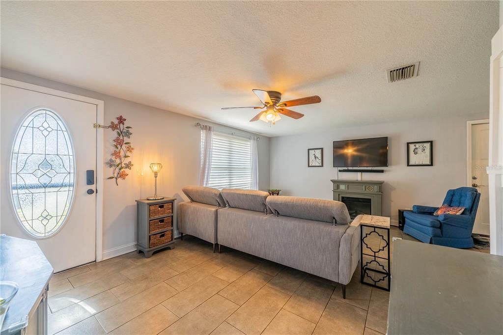 THE LIVING ROOM IS EQUIPPED WITH A CEILING FAN AND ALSO HAS NICELY TILED FLOOR