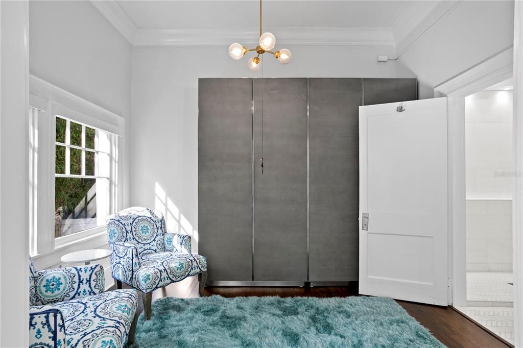 A separate wardrobe, with built in shelving, closet, and storage space and leads to the primary bath finished in gorgeous marble with an expanded shower.