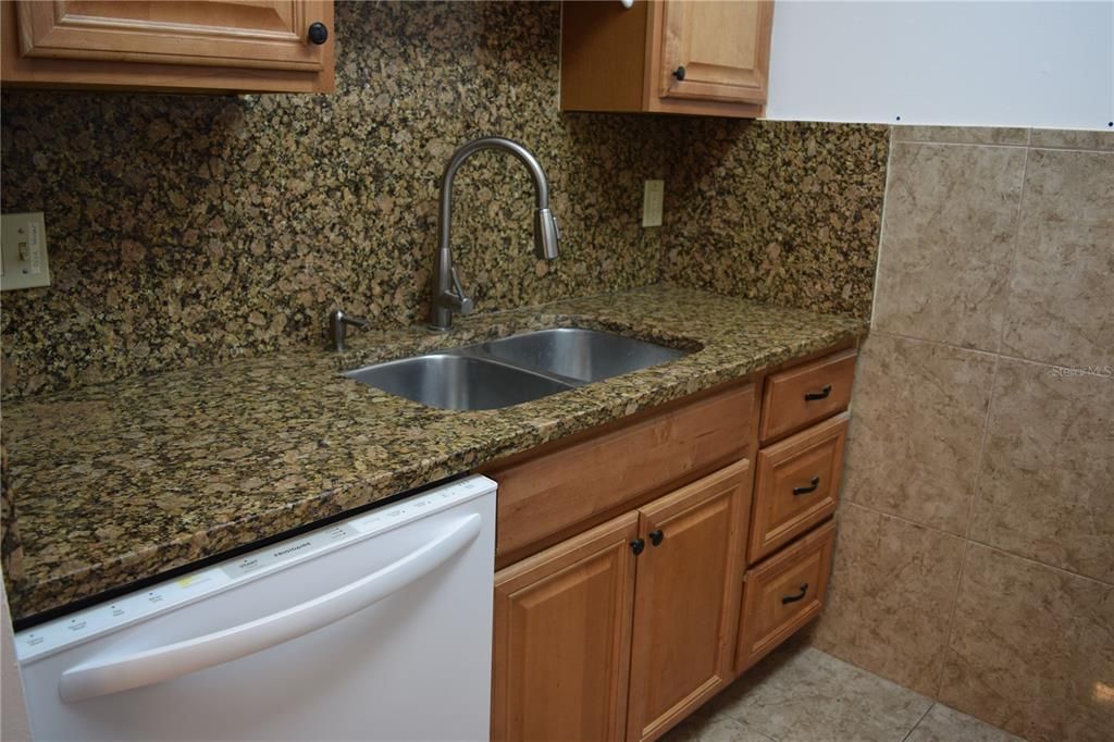 kitchen with granite counters and newer dishwasher