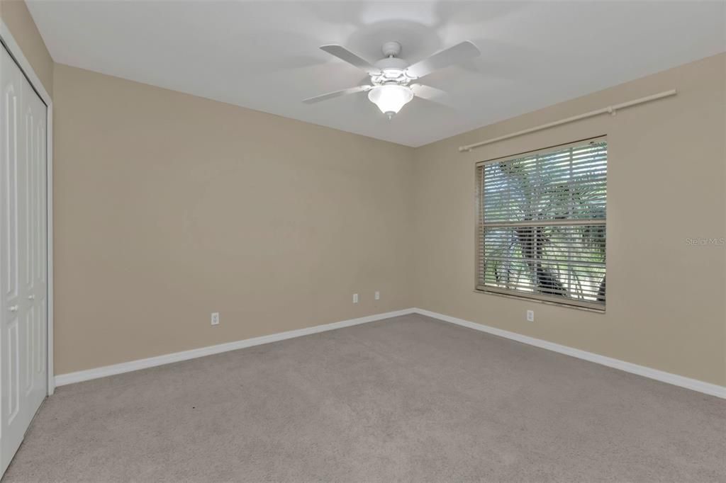 Guest bedroom 2 with carpet and built in closet.