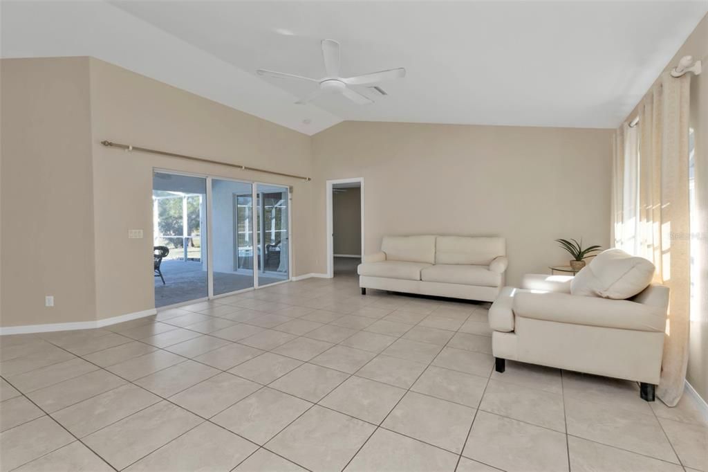 Living room has sliding glass doors to pool and lanai.