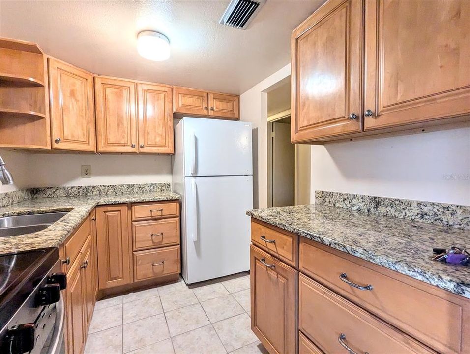 Granite countertops with beautiful wood cabinetry.