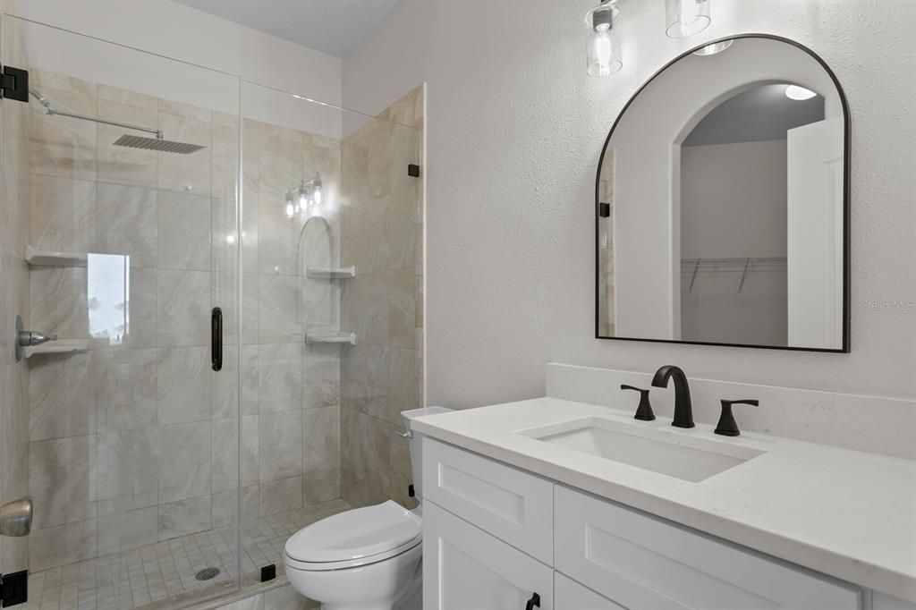 The primary bath has been fully remodeled to include new lighting, fixtures, vanity, quartz counters and a spacious frameless shower