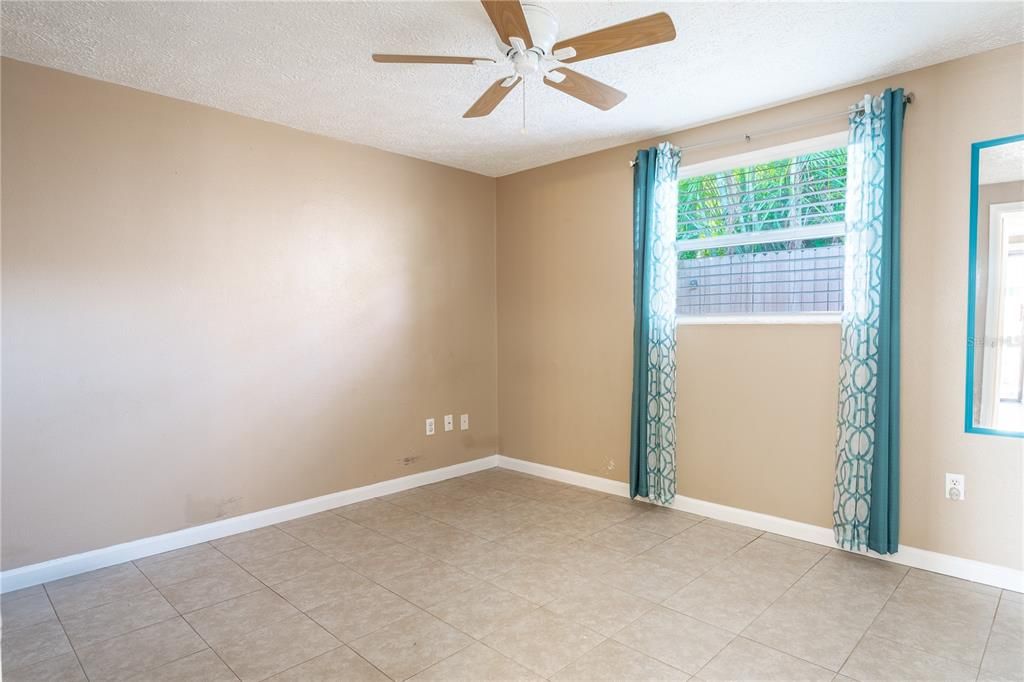 Bedroom 3 features neutral tones, ceramic tile flooring, a built-in closet, and a ceiling fan with a light kit.