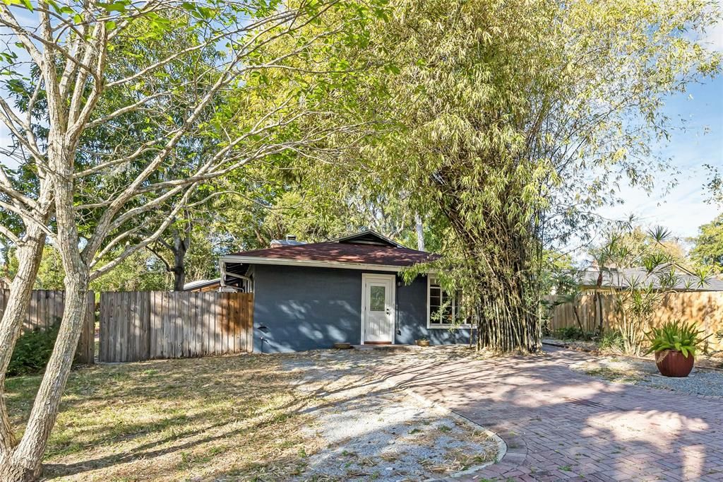 Side of the home with a brick paver driveway.