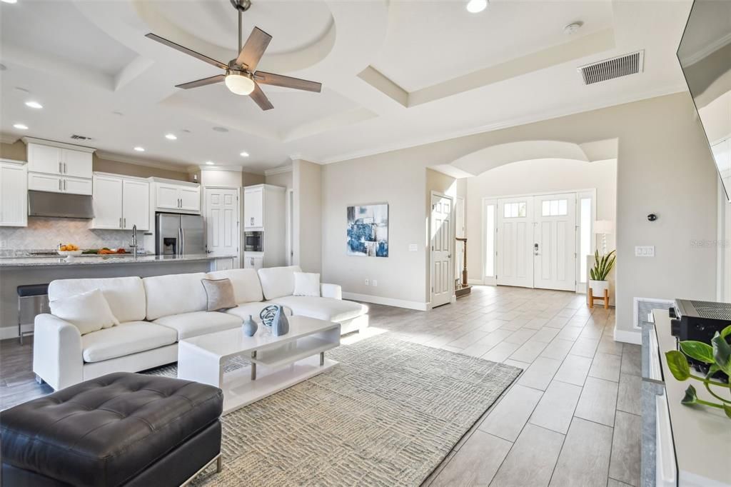 Access to the single car garage is just beyond the partial wall to the left of the picture.  Access to the two car garage is down the hallway, past the laundry room to the right of the double entry doors.