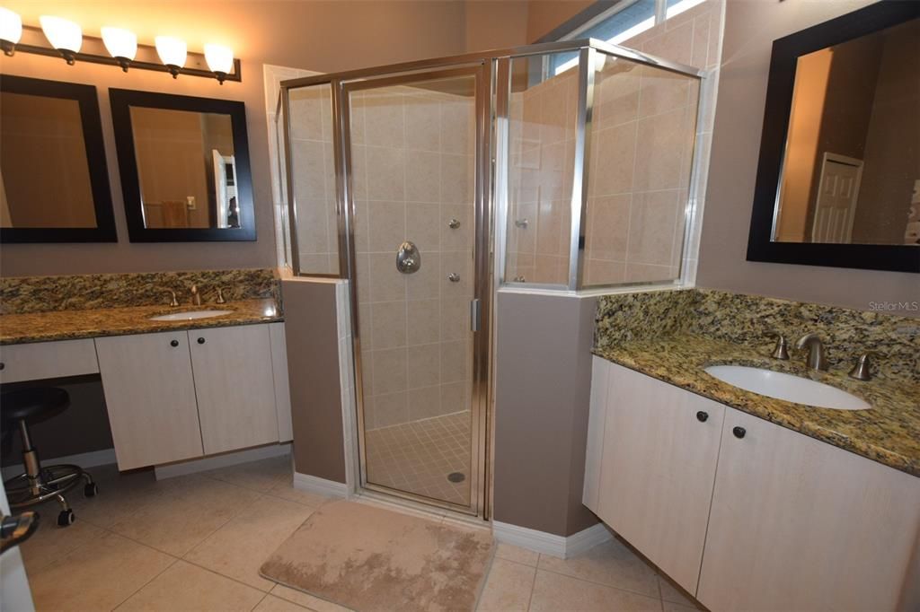 The ensuite is equipped with split vanities, sinks and stone granite countertops.  Above the spacious glass shower enclosure w/ multiple shower heads. are a set of windows allowing natural light to flow in....