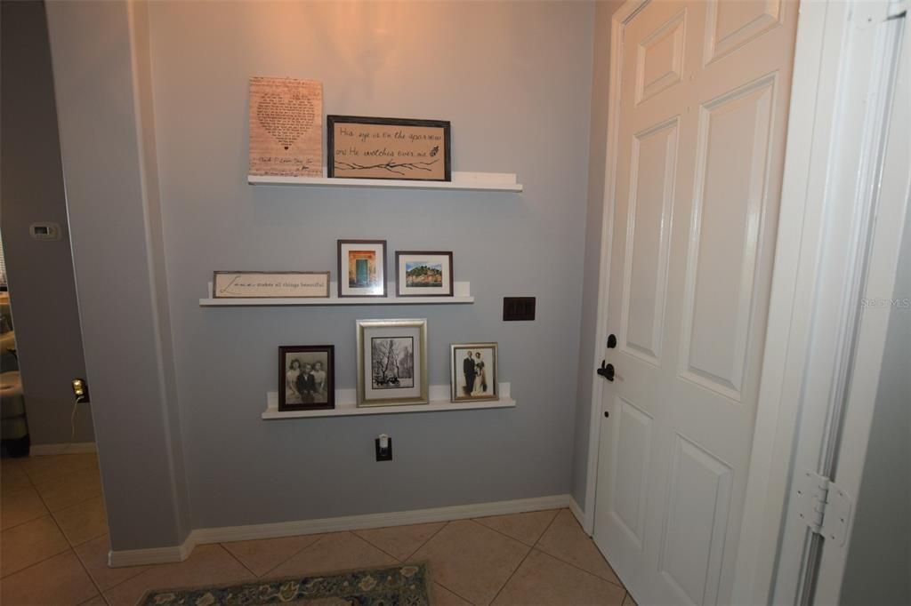 The equipped with ledged floating shelves foyer with your favorite family photos and/or images welcomes arriving guests.