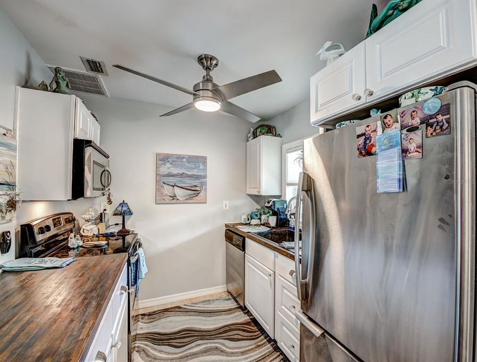 The updated kitchen boasts butcher block countertops and stainless appliances.