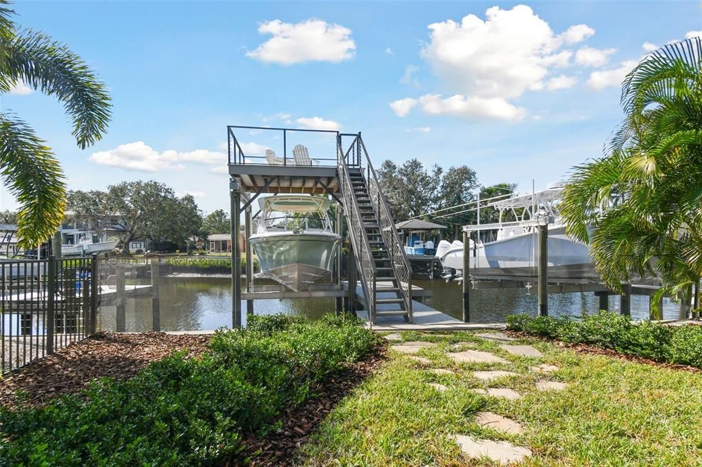 Stone pathway leads to two-story dock with 13K boat lift