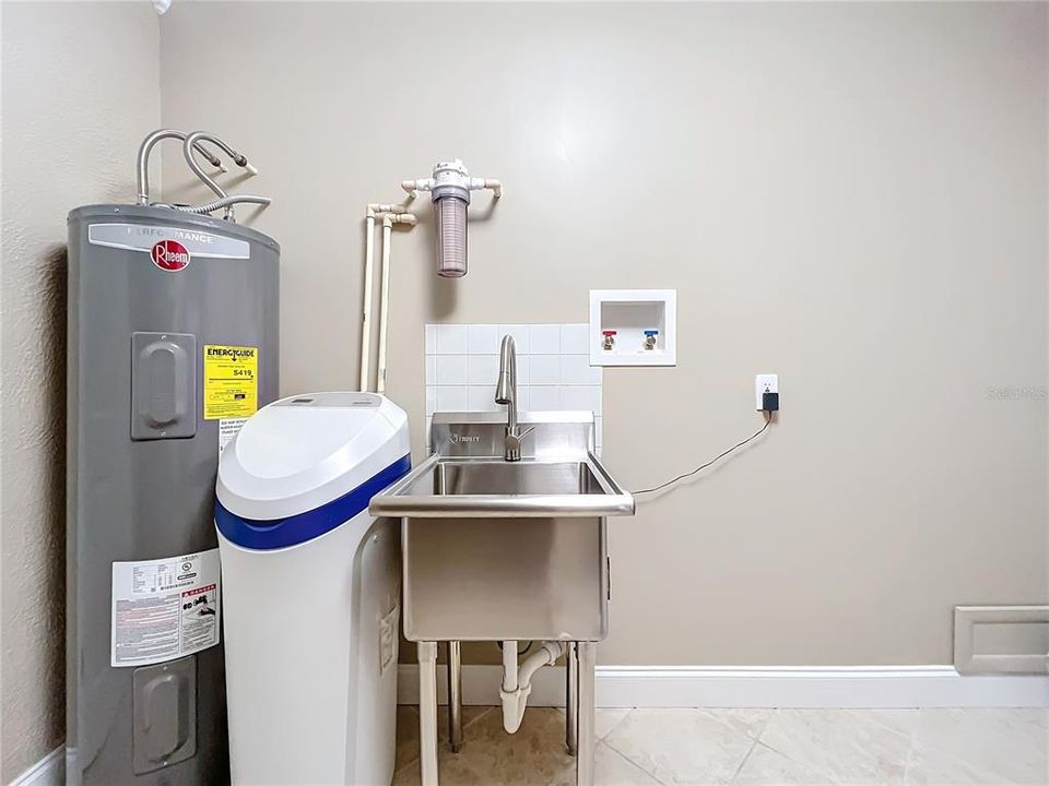 Water filtration system and water softener are in laundry room.