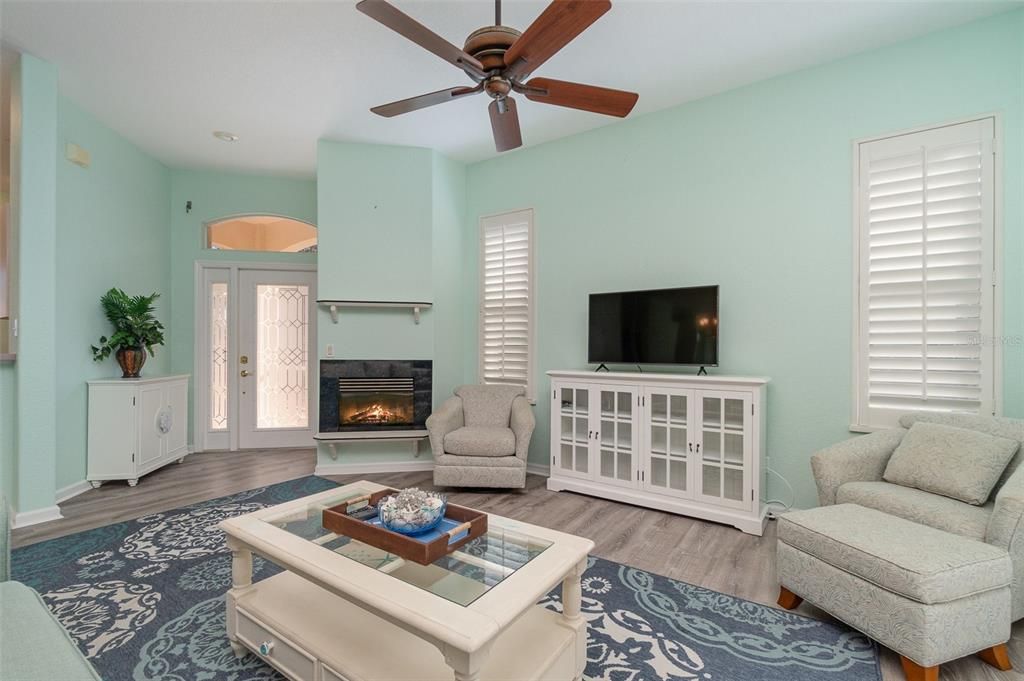 Great Room with Ceiling Fn Plantation Shutters and Fireplace