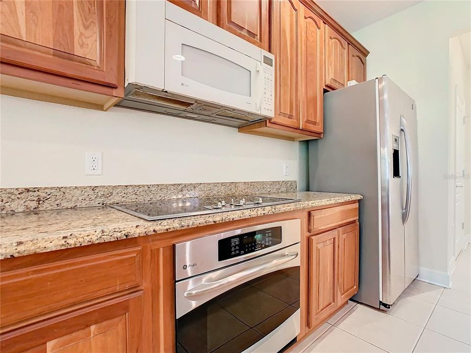 A view of the range, microwave, and refrigerator.