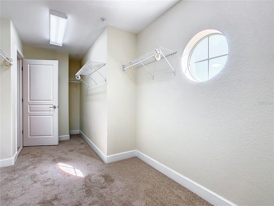 Another view of the walk-in closet in the primary bedroom with a window that looks out toward the front of the home.