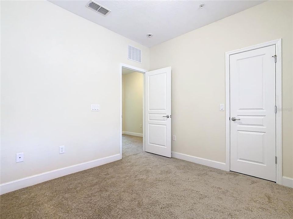 Another guest bedroom with a walk in closet.