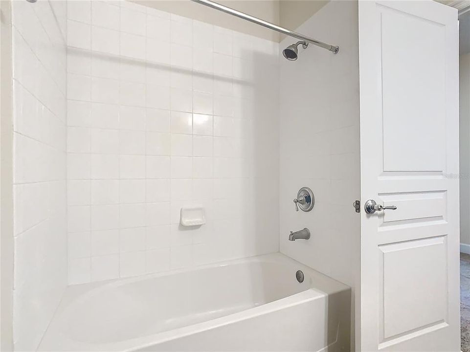 A view of the clean shower and tub.