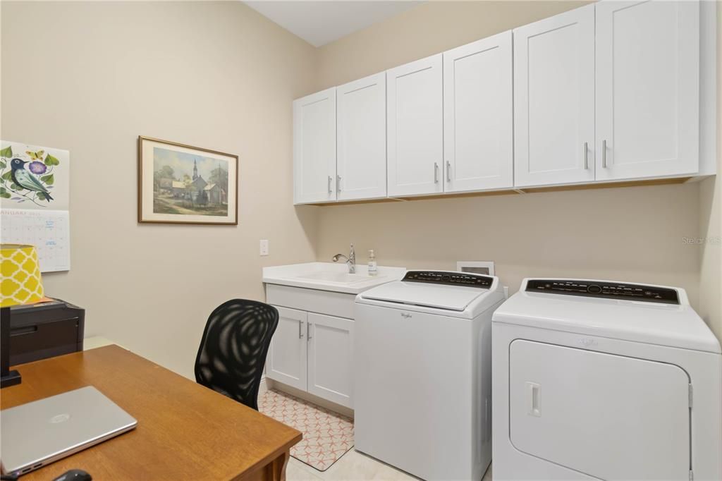 Inside laundry has sink, washer/dryer and cabinetry for storage - it is large enough for a computer desk as well.