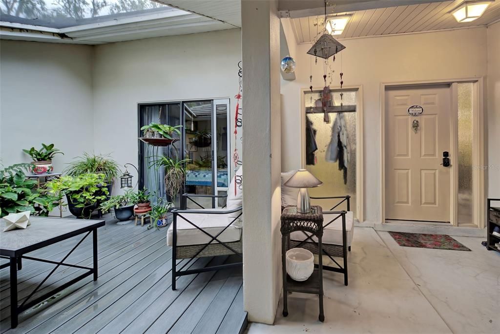 Here you have an enclosed tranquil deck area with a sliding glass door into the guest bedroom.  There is also seating under cover and the front door to the home.