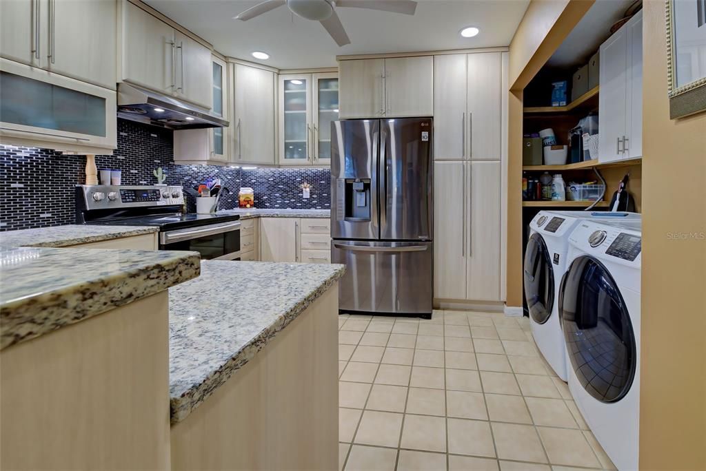 The washer and dtyer are strategically placed in the kitchen for convenience.