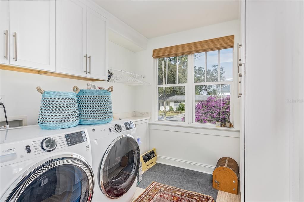 Laundry room with storage system off of kitchen