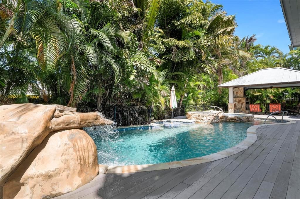 Outdoor pool deck and cabana with fireplace