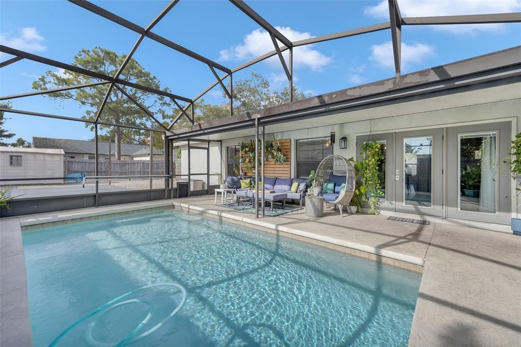 Covered patio with screened in pool.