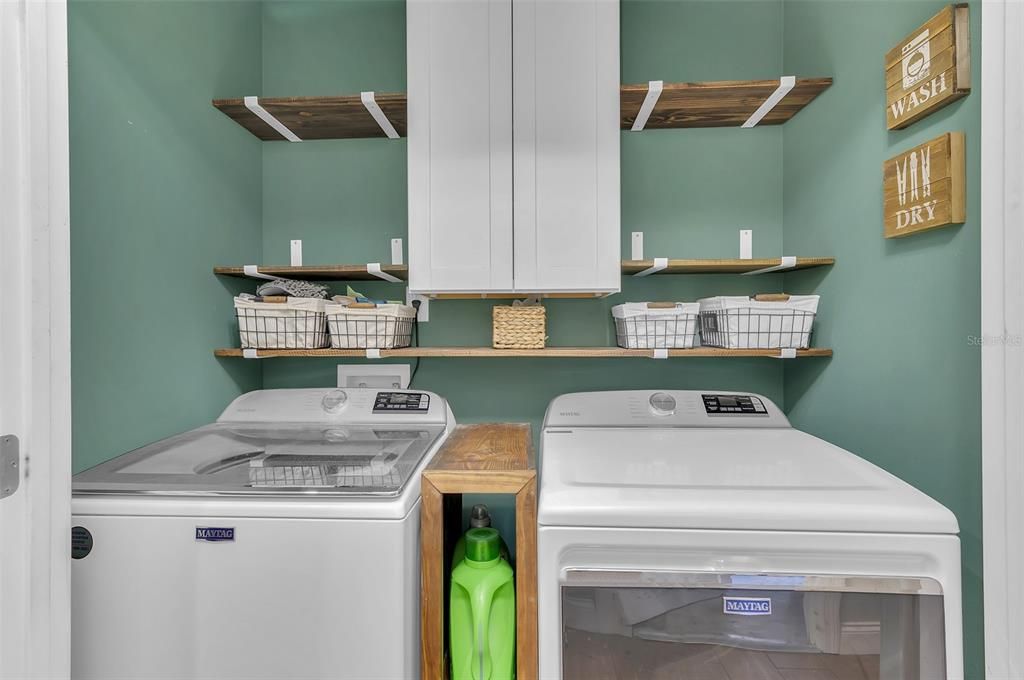 Laundry closet with shelves and cabinets.