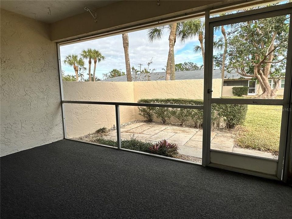 Screened Lanai and Open Patio with privacy wall and greenspace view