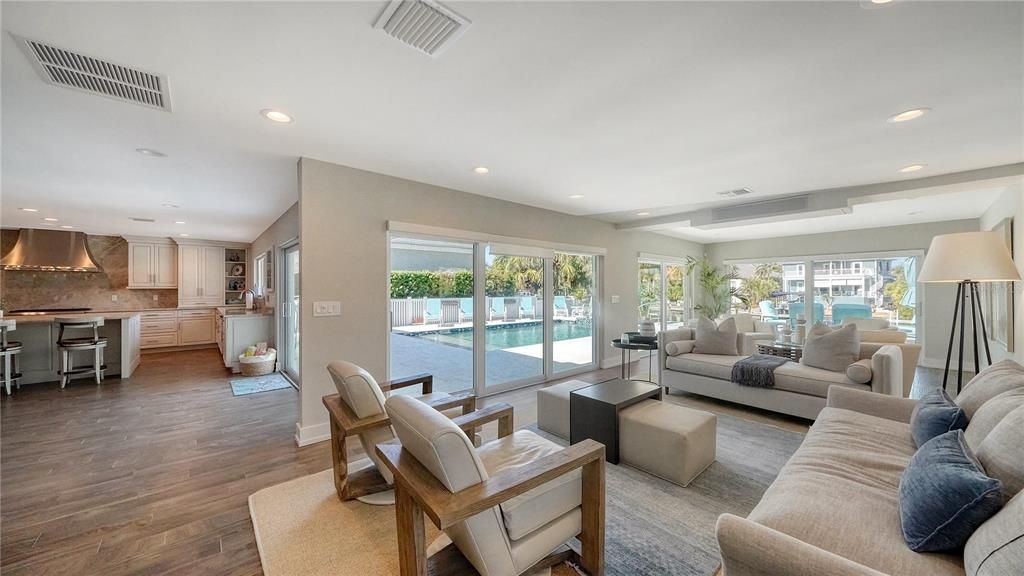 Family room is enhanced with multiple sets of glass sliders inviting natural light in.