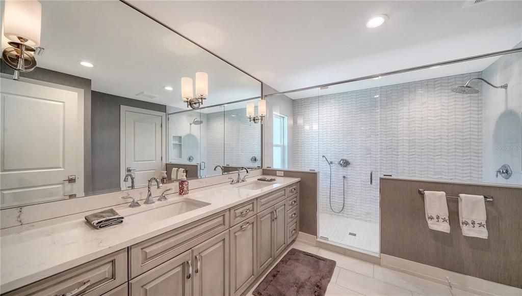 Generously sized primary full bath offers double sinks, custom shower, and water closet.