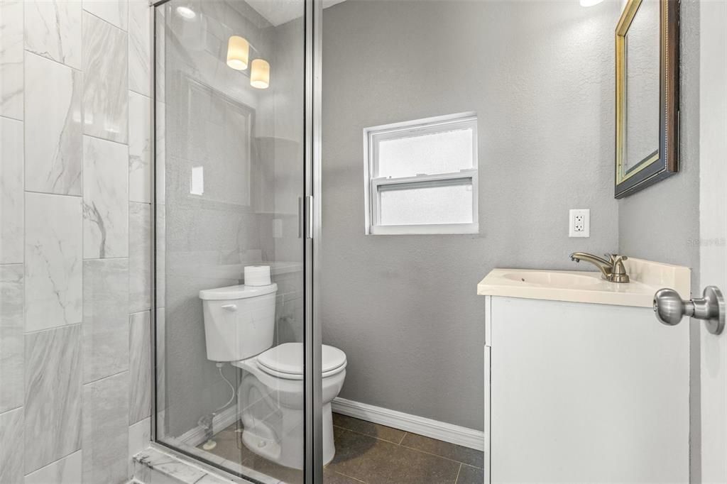 Hall bath with shower stall.