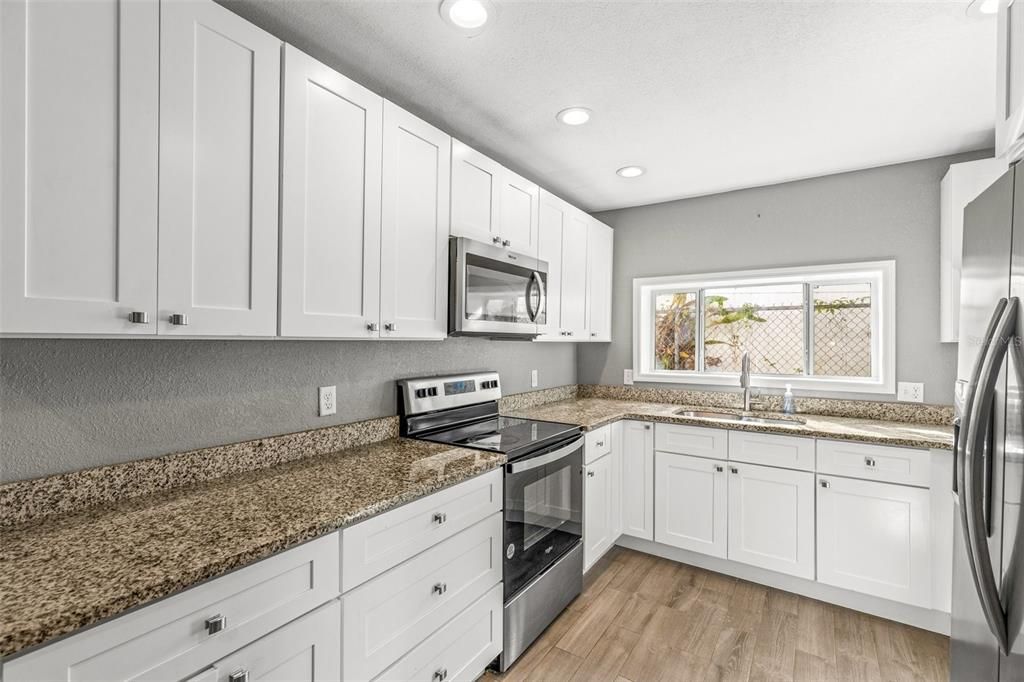 Kitchen includes granite counters, wood cabinets and lots of natural light.