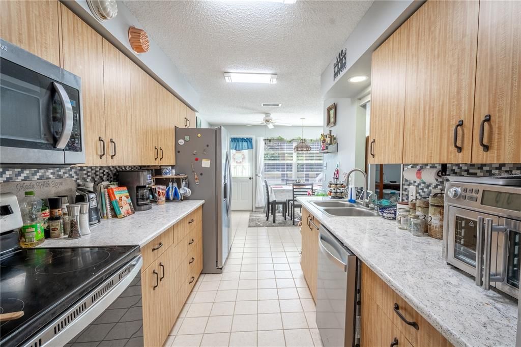 The galley kitchen is designed for convenience with solid surface quartz counters and plenty of cabinet space for storage.